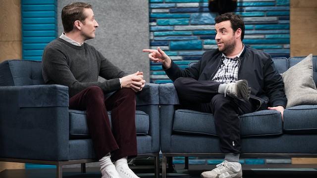 David Krumholtz Wears a Blue Zip-Up Jacket and Grey Sneakers